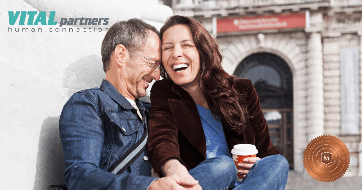 A man and woman sit close together outdoors, laughing and enjoying each other’s company. The woman holds a coffee cup. “VITAL partners human connection” is written in the top left corner.